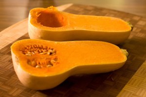 Calabaza cacahuete cortada por la mitad, con la carne naranja y las semillas