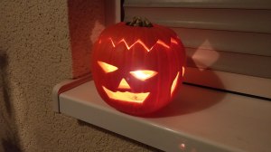 Calabaza de Halloween tallada e iluminada en una ventana