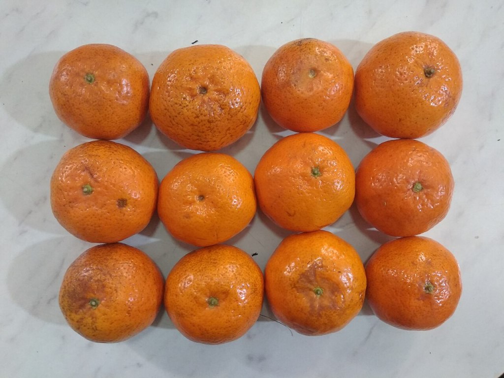 Doce mandarinas sobre una encimera de mármol